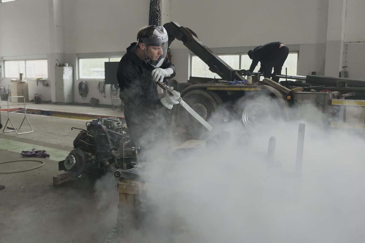 Trockeneisstrahlen mit Dampfwolke in der Werkstatt